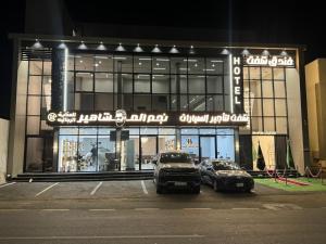 two cars parked in a parking lot in front of a building at فندق شفت جازان Shift Jizan Hotel in Jazan