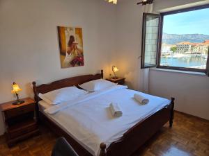 a bedroom with a bed and a large window at Apartments Romana in Postira