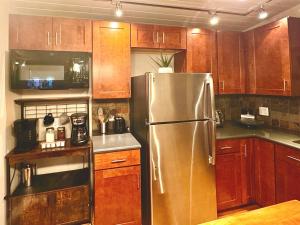 a kitchen with wooden cabinets and a stainless steel refrigerator at Perfect Couples Getaway Private Hot Tub Panoramic Red Rock Views in Sedona