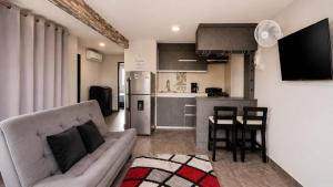 a living room with a couch and a kitchen at Apartamentos cerca al centro de Cali in Cali