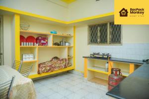 a kitchen with yellow walls and shelves and a table at Zapstays-Homestays in Visakhapatnam +16 photos