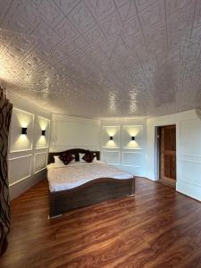a bedroom with a bed and a coffered ceiling at The Nigeen Lodge in Srinagar