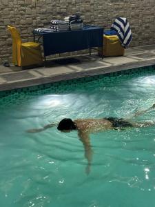 a person swimming in a swimming pool at Hotel paras in Dera Bassi