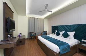 a hotel room with a bed and a television at Hotel paras in Dera Bassi