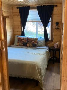 a bed in a log cabin with a window at Ak backcountry retreat in Kenai