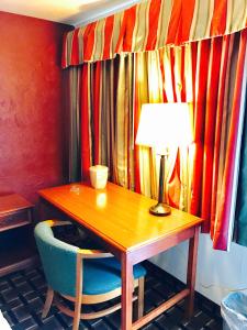 a desk with a lamp and a chair with a table at Greystone Motel in Hillsboro