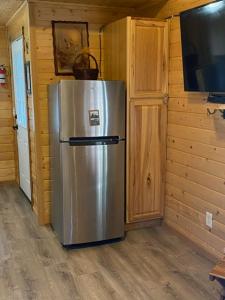 a stainless steel refrigerator in a room with a tv at Ak backcountry retreat in Kenai