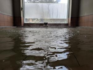 an empty room with water on the floor in front of a window at Ryokan Ichinomatsu in Hakodate