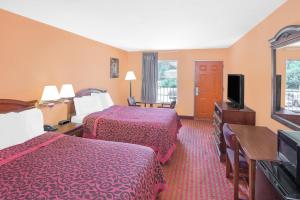 a hotel room with two beds and a flat screen tv at America Best Value Inn Kosciusko in Kosciusko