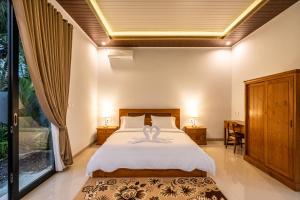 a bedroom with a bed with a swan on it at Alam Kasih Villa in Tampaksiring