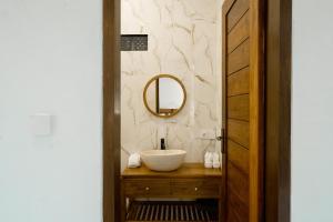a bathroom with a sink and a mirror at Alam Kasih Villa in Tampaksiring +48 photos