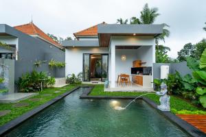 a house with a swimming pool in front of a house at Alam Kasih Villa in Tampaksiring