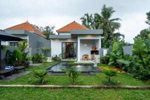 a villa with a garden and a house at Alam Kasih Villa in Tampaksiring