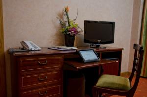 a desk with a computer and a monitor and a phone at VIP Inn Berna Hotel in Lisbon
