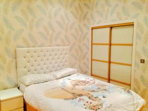 a bedroom with a bed and a wall with wallpaper at Glasgow City Center Flat with Parking in Glasgow