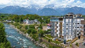 a city with a river and mountains in the background at Aachman Riviera Valley dharamshala by NAINA STAYCATION in Dharmsāla