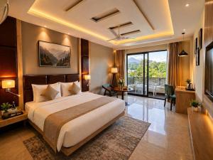 a bedroom with a large bed and a large window at Aachman Riviera Valley dharamshala by NAINA STAYCATION in Dharmsāla +32 photos