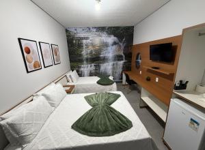 a bedroom with two beds with a dress on the bed at Alphaville Hotel in Barra do Bugres