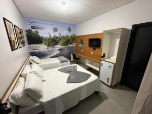 a room with two beds and a television in it at Alphaville Hotel in Barra do Bugres +12 photos