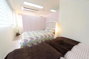 a bedroom with two twin beds in a room at Sweet House Umeda Minami in Osaka