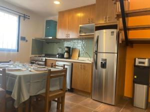 a kitchen with a table and a stainless steel refrigerator at Casa Granada in Guanajuato