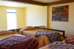 Habitación con 2 camas y ventana en Departamentos Santa Ana Barrio Tradicional, en Cusco