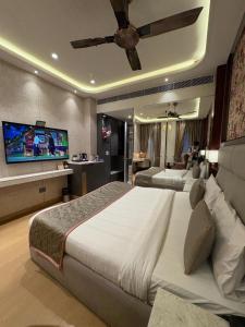 a bedroom with a large bed and a flat screen tv at Hotel Rajshree & Spa in Chandīgarh