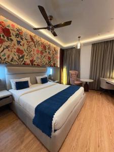 a bedroom with a large bed with a ceiling fan at Hotel Rajshree & Spa in Chandīgarh