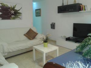 a living room with a couch and a tv at Maison Lamic 1 in Lloret de Mar