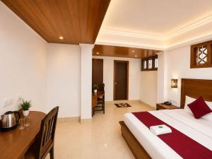 a bedroom with a bed and a desk and a table at Gangtok Central Rooms in Gangtok