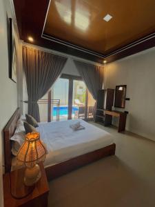a bedroom with a bed with a lamp and a window at NeNa Eat & Sleep Kuta in Kuta Lombok