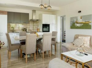 a kitchen and living room with a table and chairs at Villa Peace Oasis in Lovreć
