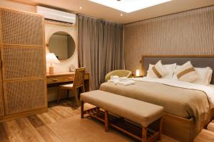 a bedroom with a bed and a desk and a mirror at Island Ufaa Dharavandhoo in Dharavandhoo