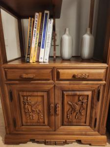 a wooden cabinet with books and vases on top at 러너리 스테이 in Seoul
