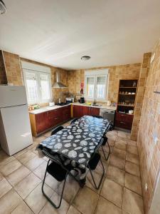 a kitchen with a table and a refrigerator at Casa Rural Vacacional in Puerto Real
