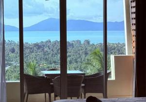 a room with a table and chairs and a view of the ocean at Sea-view apartment in Azur in Ban Tai