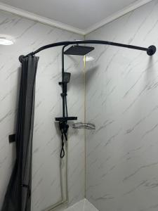 a shower in a room with a shower curtain at Tosor Guest House Medet in Tossor