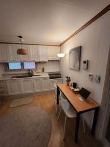 a kitchen with a table with chairs and a laptop on it at 러너리 스테이 in Seoul