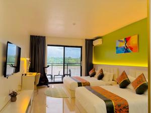 a hotel room with two beds and a large window at Nausori Plaza Hotel in Vunimono