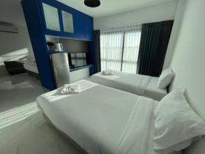a bedroom with two beds and a blue wall at A Day Hotel in Roi Et