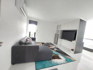 a living room with a couch and a tv at A Day Hotel in Roi Et