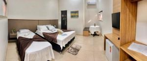 a bedroom with two beds and a flat screen tv at Hotel Fazenda Haras Paraíso do Atlântico in Irecê +37 photos