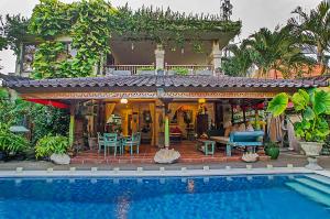 a house with a swimming pool in front of it at Villa Kaja by Nagisa Bali in Seminyak