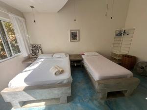 a room with two beds and a table in it at Casa Nisadó in San Agustinillo