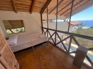 a bedroom with a bed and a view of the ocean at Casa Nisadó in San Agustinillo