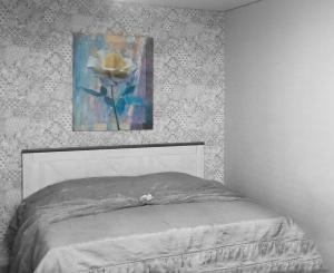 a bedroom with a bed with a painting on the wall at Luna in Tiraspol