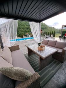 a living room with couches and a table and a patio at Etno Selo Relax in Šipovo
