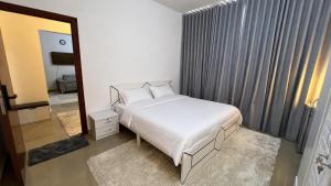 a bedroom with a white bed and a mirror at Banny Homes - Cozy Suite Apartment - Downtown in Abu Dhabi