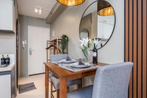 a dining room with a table and chairs and a mirror at Airport Haven Condotel - near Mactan-Cebu Airport 13 mins ride, Self Check-In, Wifi, Netflix, pool and Balcony view in Lapu Lapu City
