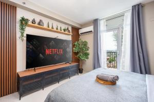 a bedroom with a flat screen tv on a wall at Airport Haven Condotel - near Mactan-Cebu Airport 13 mins ride, Self Check-In, Wifi, Netflix, pool and Balcony view in Lapu Lapu City